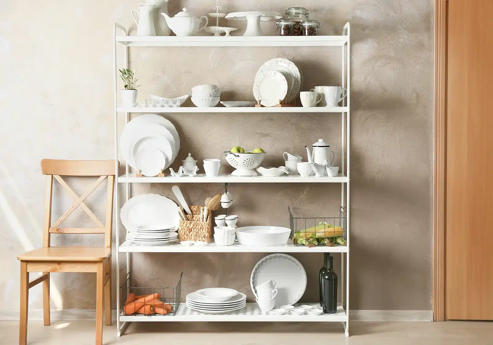 A freestanding shelving unit in a kitchen displaying an array of white dishes and kitchenware, adding storage and style to the space.