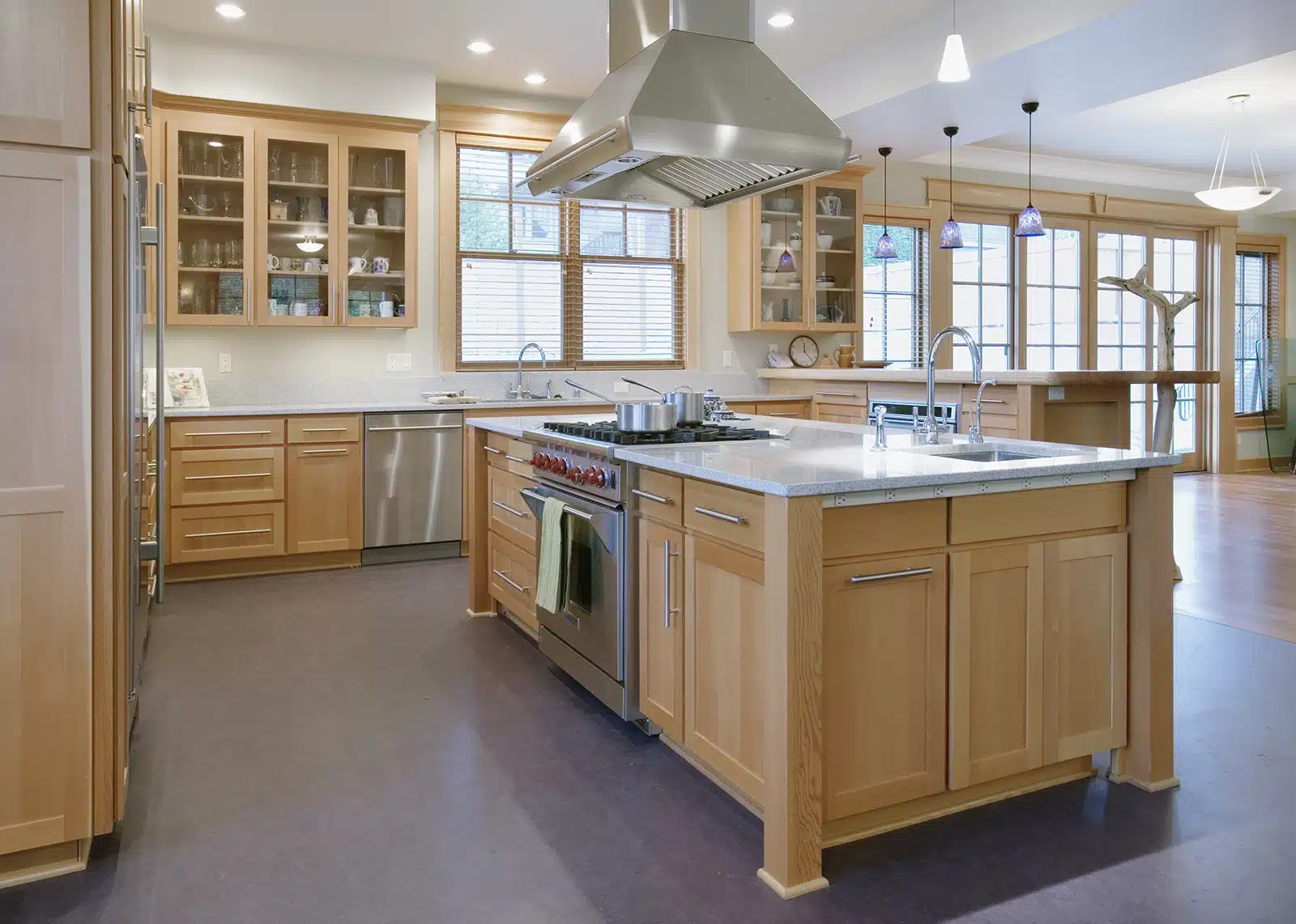 A well-appointed kitchen featuring generous clearances around a central island, natural wood cabinetry, and modern appliances, designed for optimal flow and functionality.