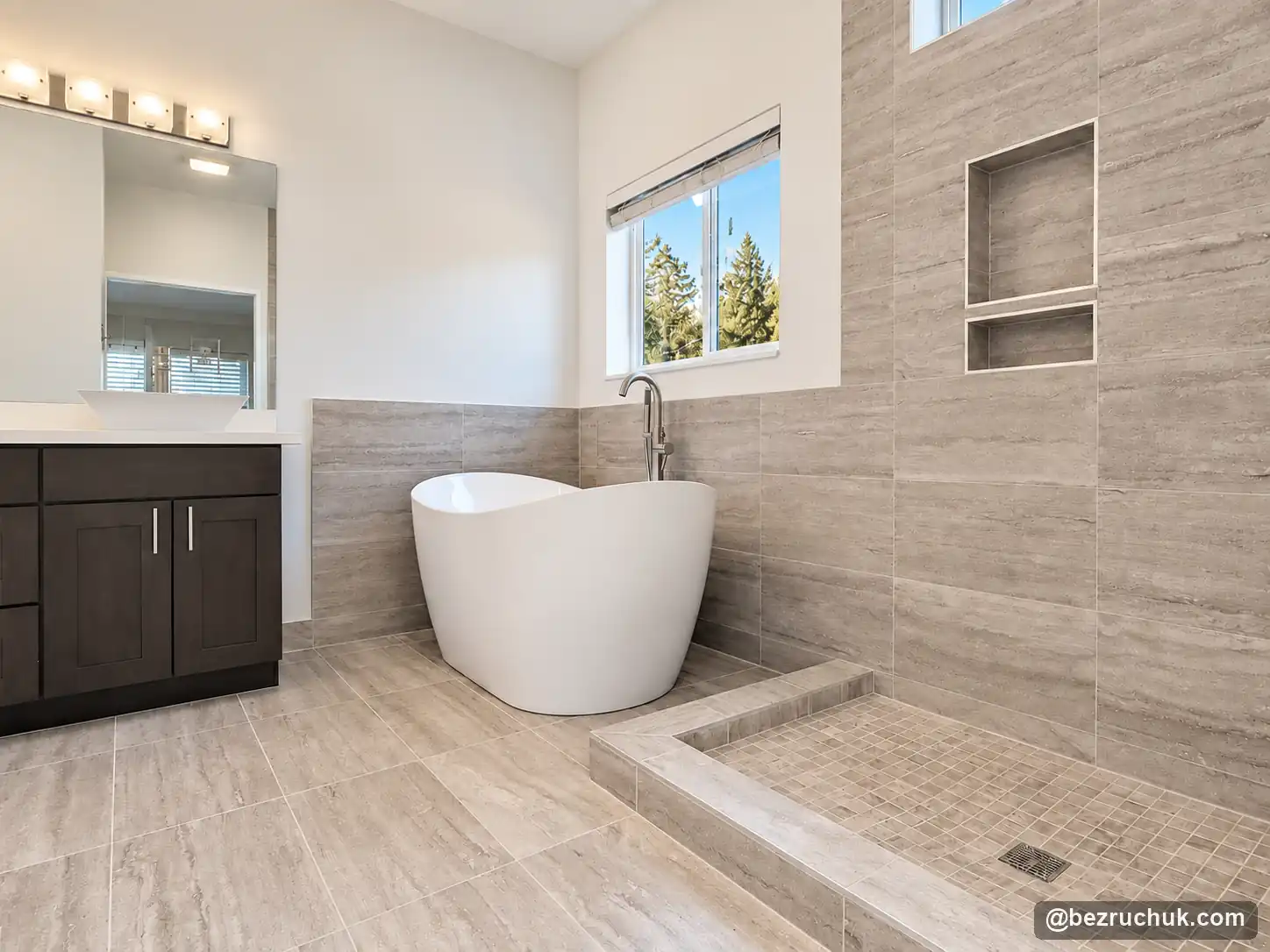 Bathroom renovation Renton WA after water damage, with freestanding tub and gray tiled shower