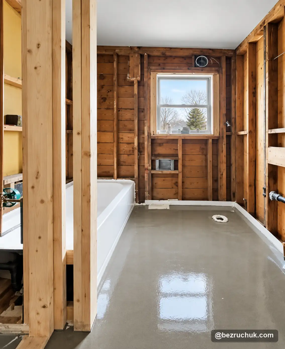 - project image Exposed wall framing around the tub and window during the older home bathroom remodel
