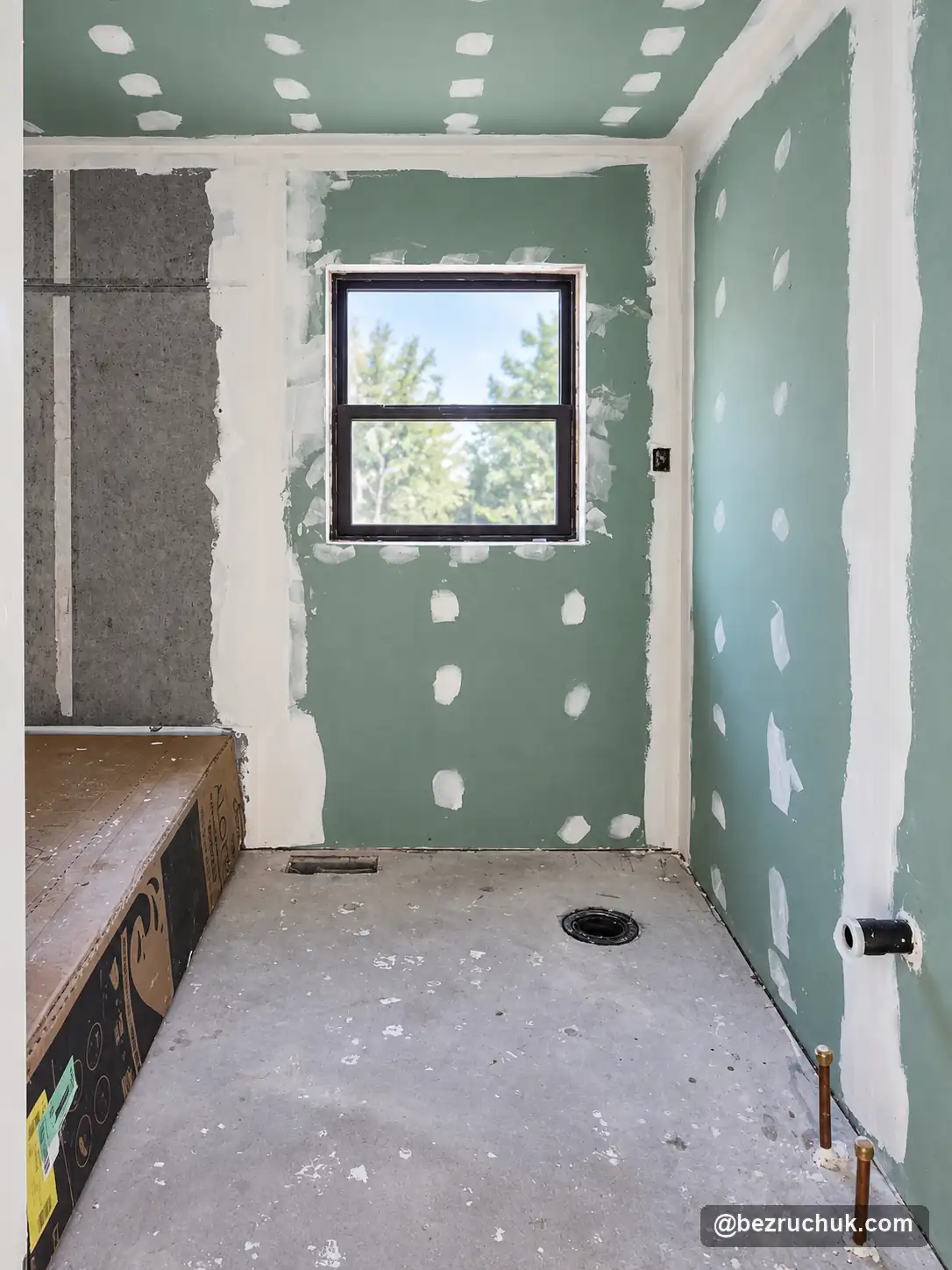 - project image Green wallboard and taped joints around the bathroom window during construction