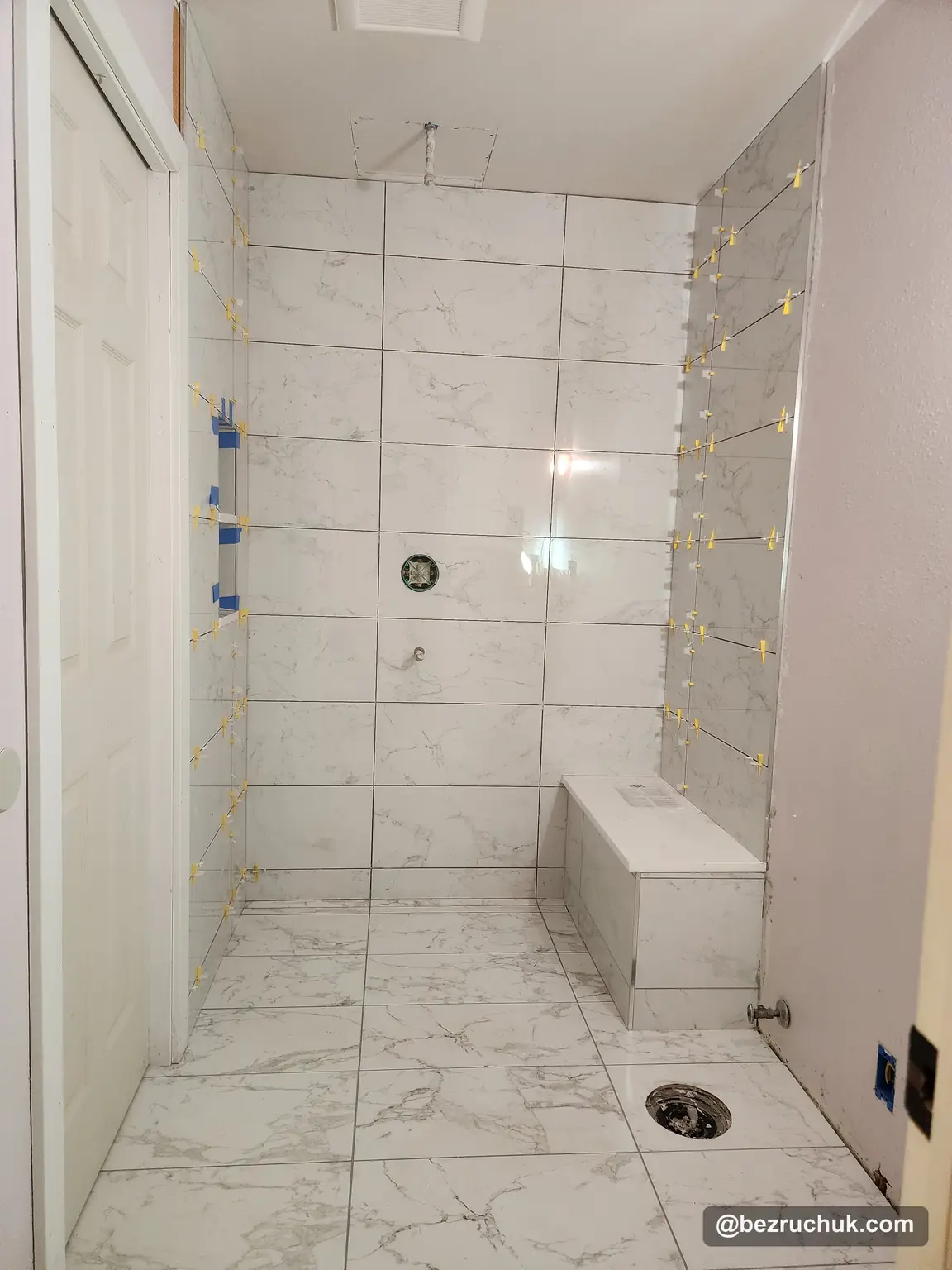 - project image Porcelain shower wall and floor tile during installation around the built-in bench