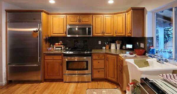 - project image Before water damage kitchen restoration in Puyallup with older wood cabinets and sink area