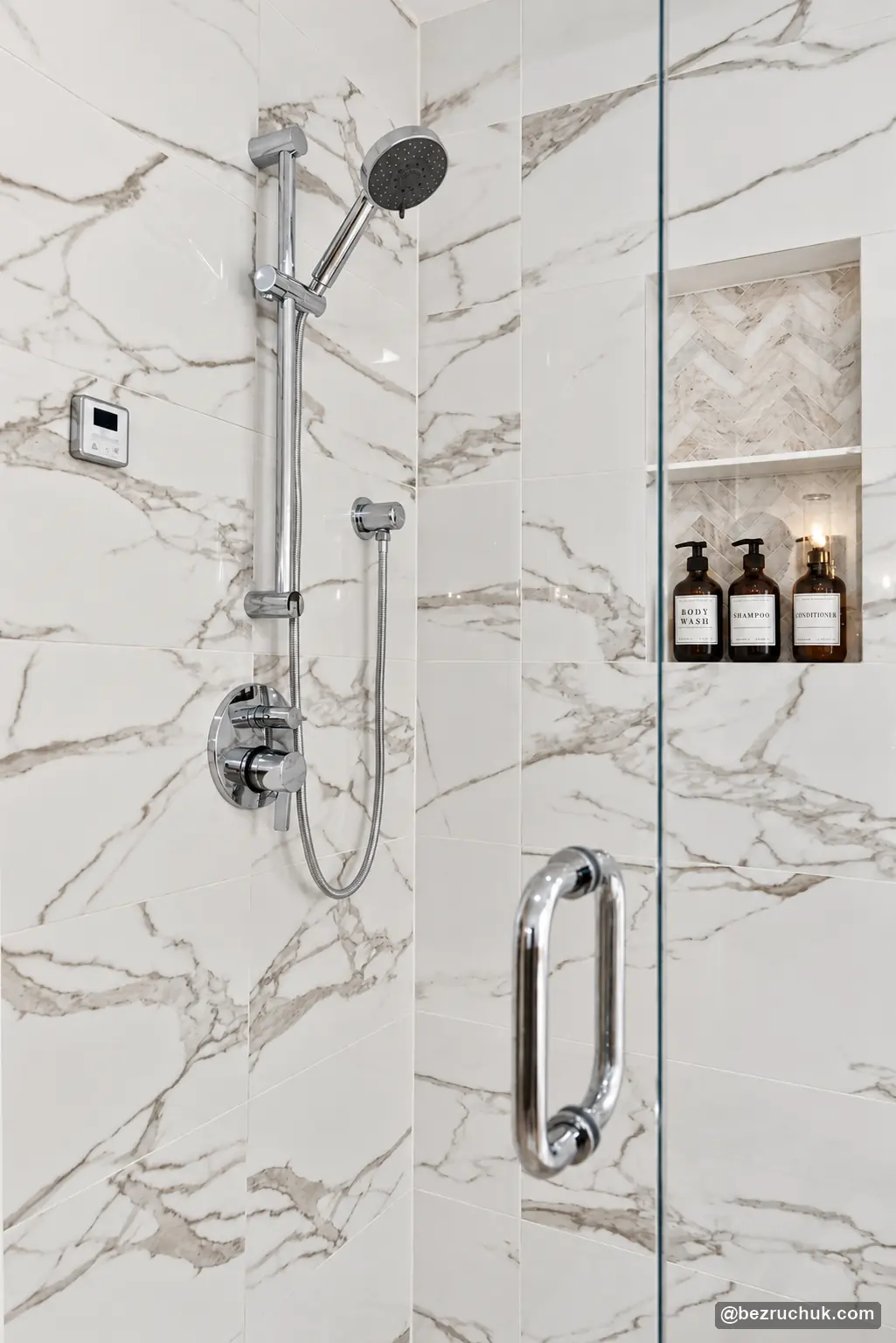 Chrome shower fixtures and recessed storage niche in marble-look tile in steam shower remodel Duvall, WA.