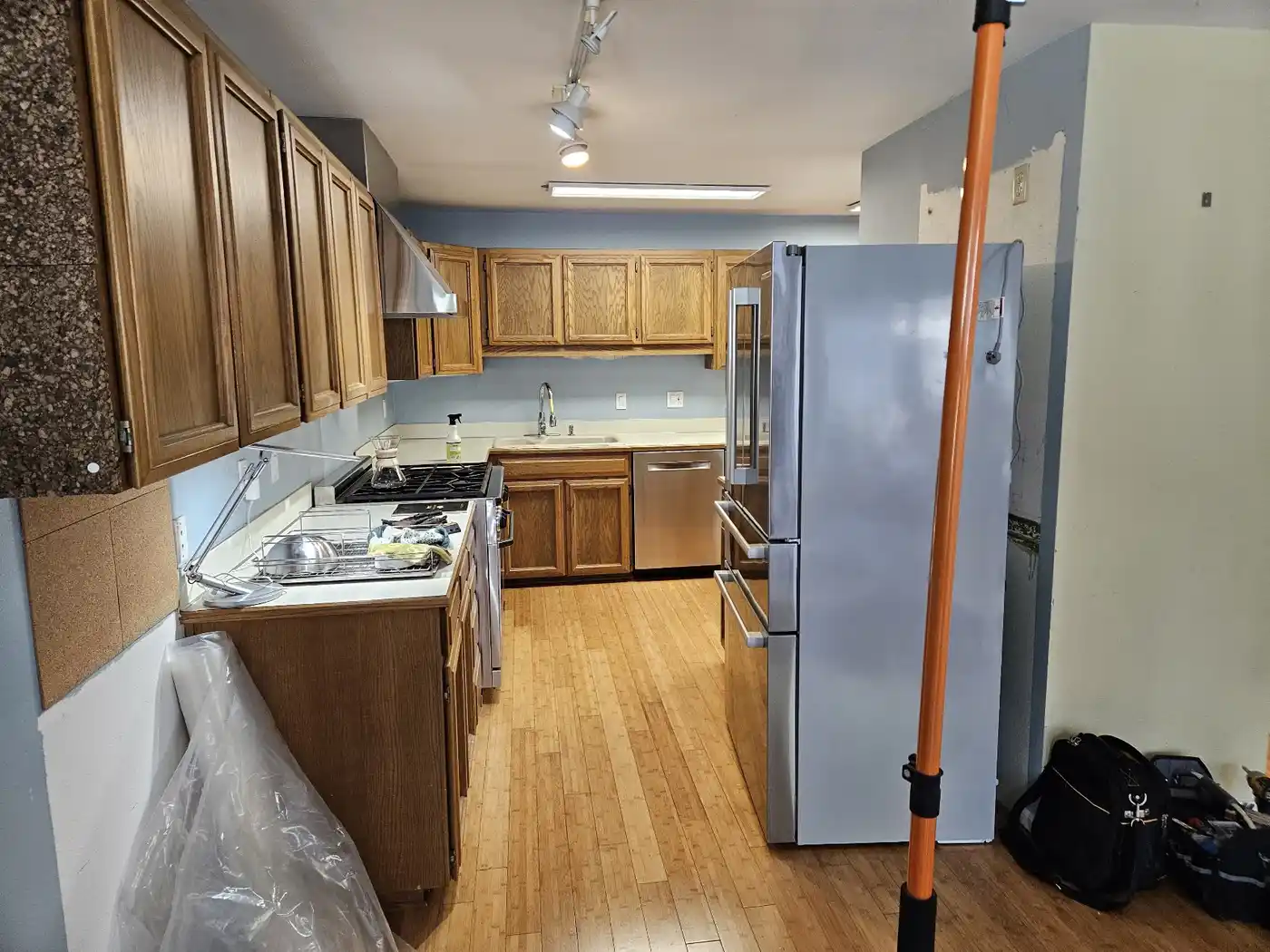 Bellevue kitchen before demolition with flooring removed and a temporary plastic-wall support post visible