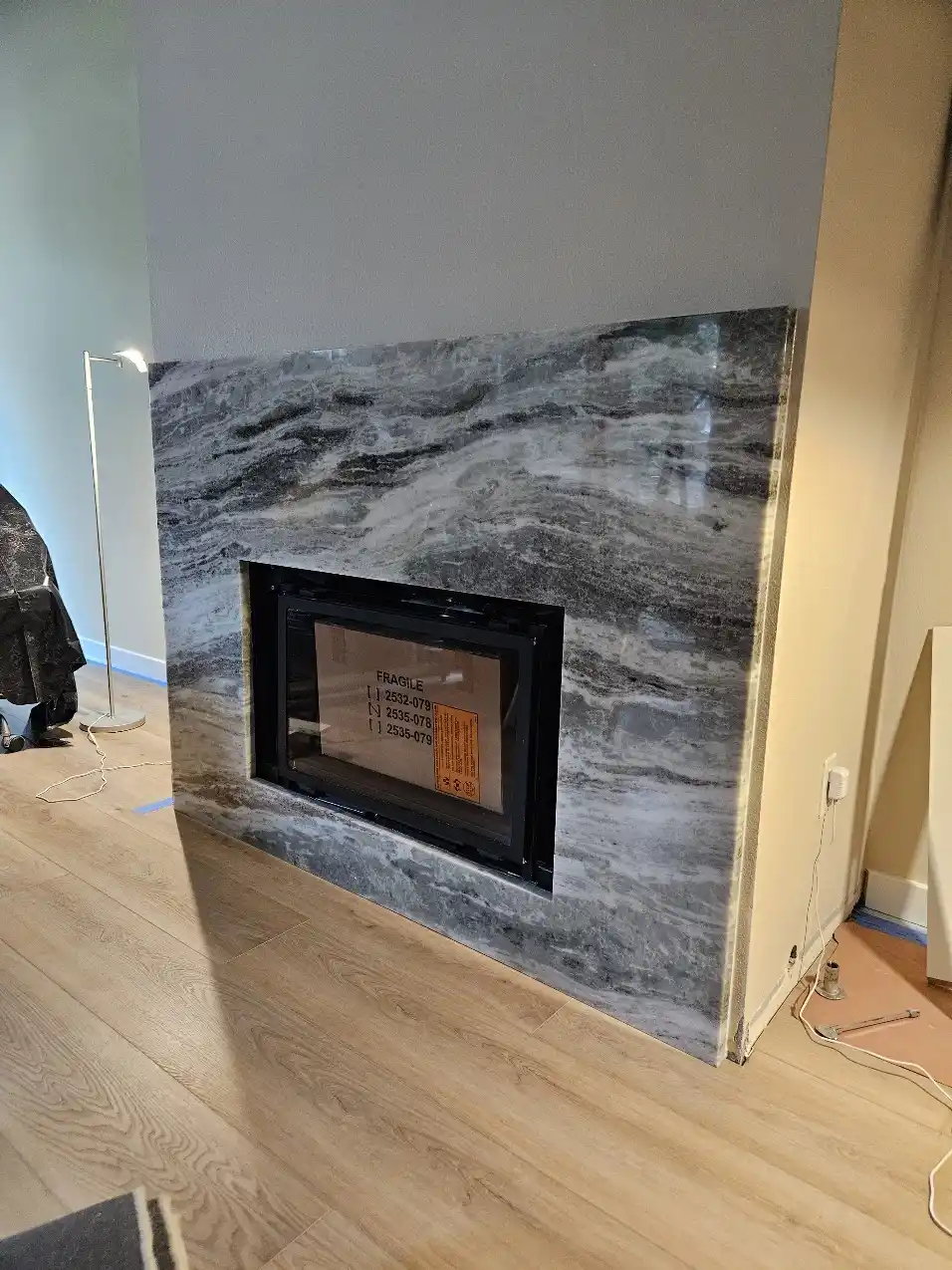 Fireplace stone slab installation during the Bellevue main-floor remodel
