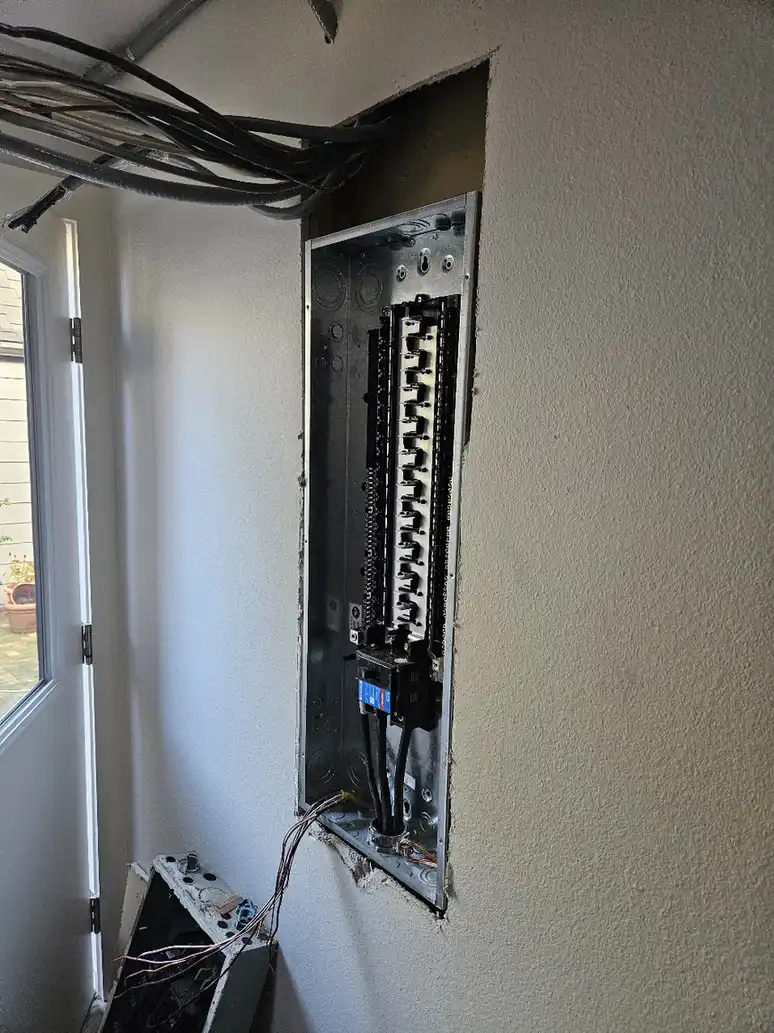 Licensed electrician replacing the outdated panel during the Bellevue remodel