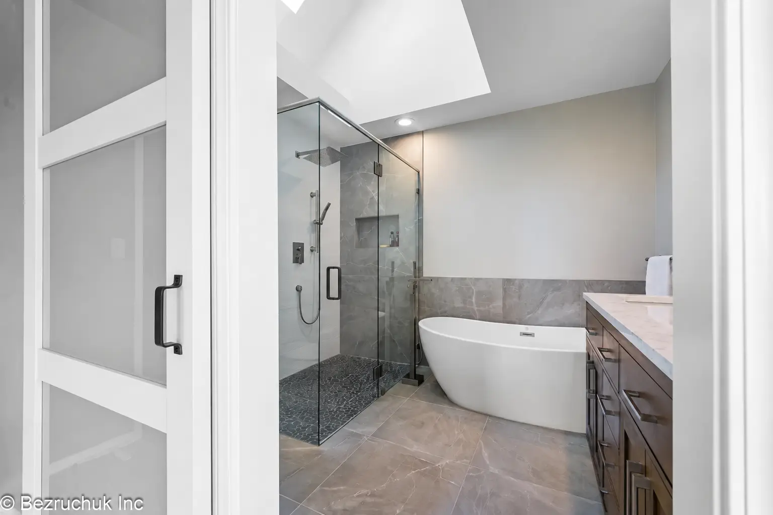 Finished curbless shower remodel in Carnation with a glass shower, freestanding tub and wood vanity
