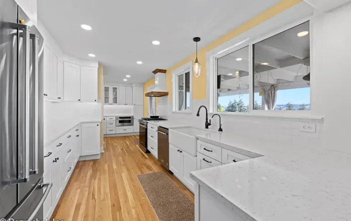 Edgewood kitchen renovation with white shaker cabinets, hardwood flooring, and pendant lighting.