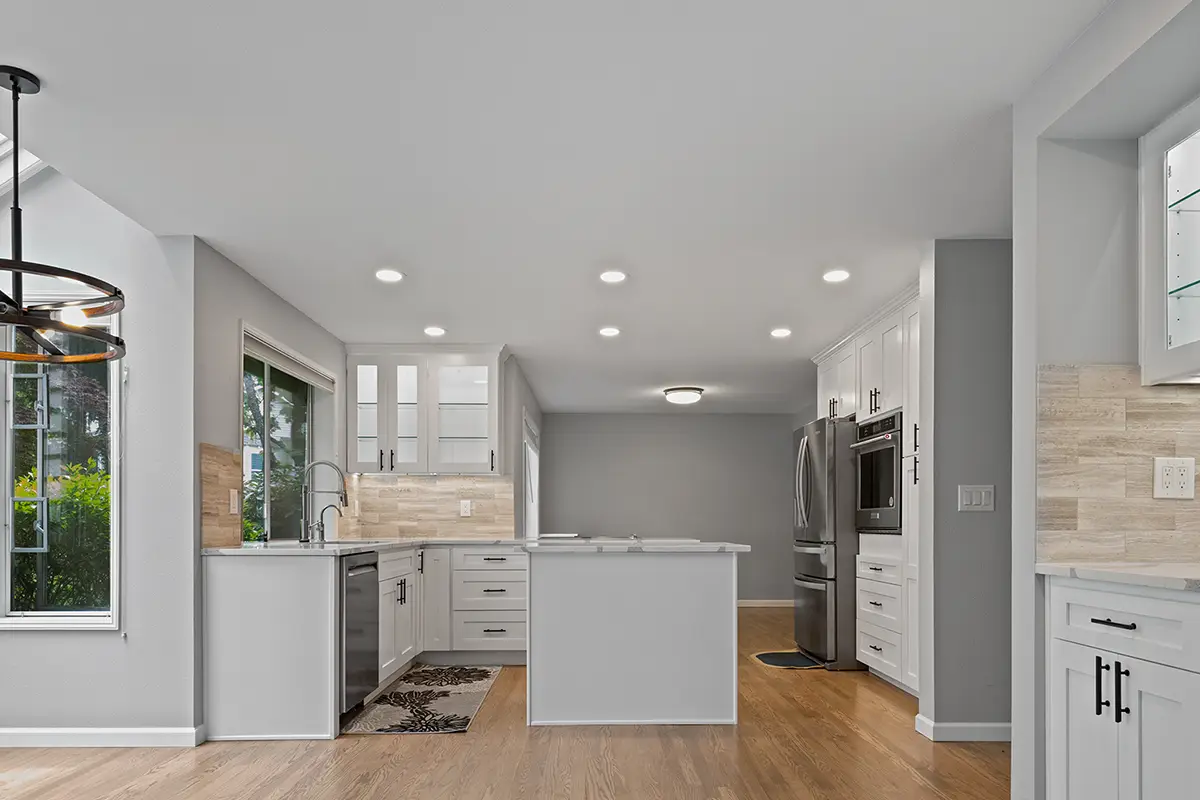 Remodeled white kitchen with shaker cabinets, quartz countertops, and LED lighting in Issaquah, WA