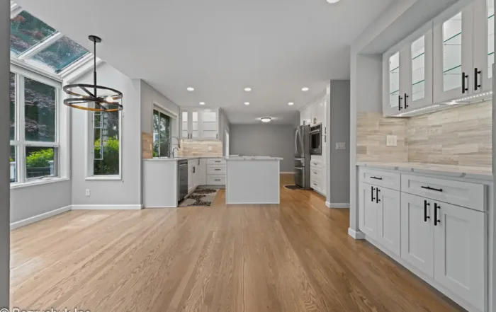 bright open-concept kitchen and dining remodel with white shaker cabinets and hardwood flooring in Issaquah