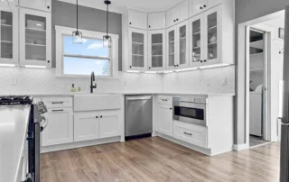 - project image Kitchen remodel in Edgewood WA with white shaker cabinets, herringbone tile backsplash, and modern lighting