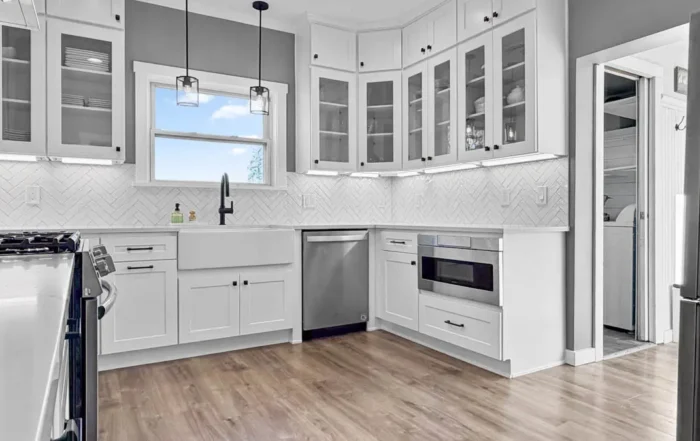 - project image Kitchen remodel in Edgewood WA with white shaker cabinets, herringbone tile backsplash, and modern lighting