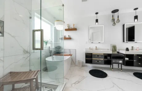 Frameless Shower Corner Detail Frameless glass shower corner with patterned floor tile and marble-look wall tile