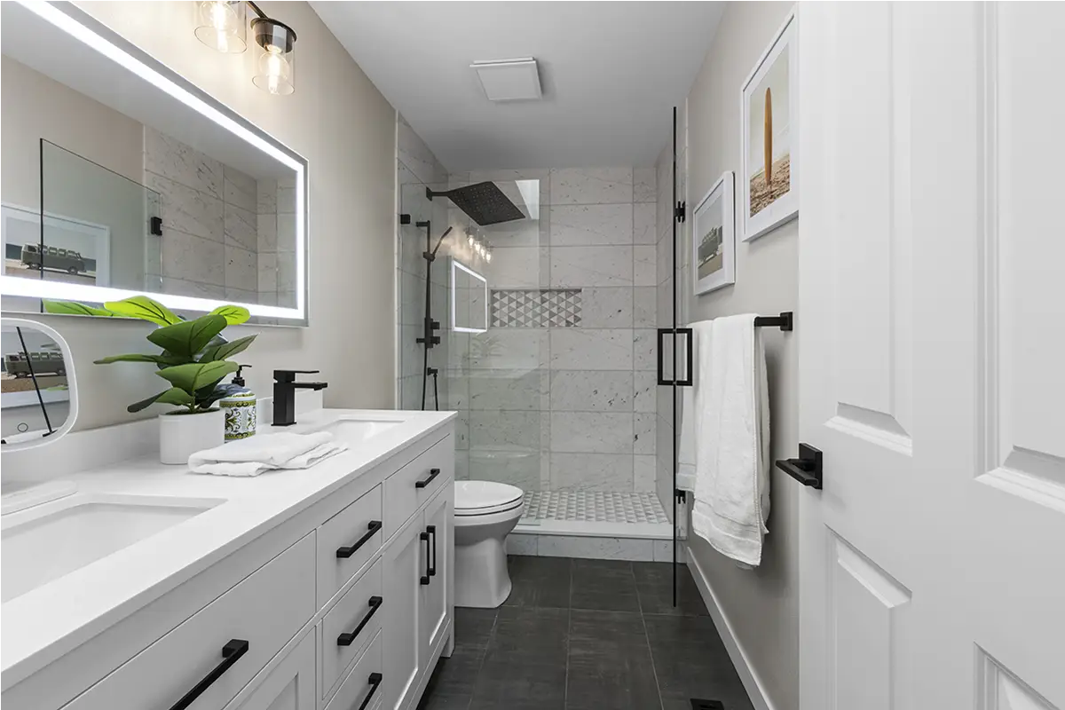 Guest bathroom remodel in Puyallup featuring white vanity, frameless glass shower, and modern tile