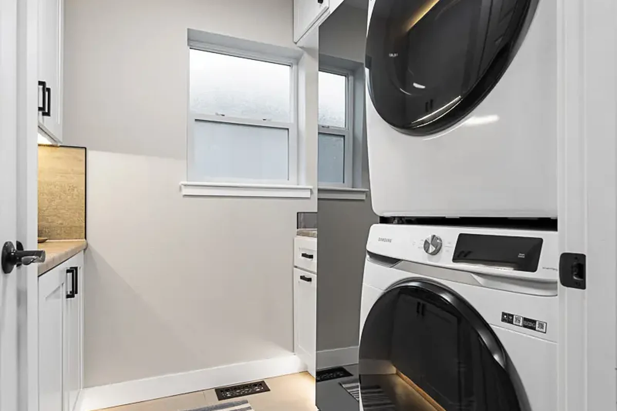 Akron Home Renovation Laundry Room Cabinetry Example Laundry room renovation example with cabinetry, utility sink, washer and dryer area, and tile floor