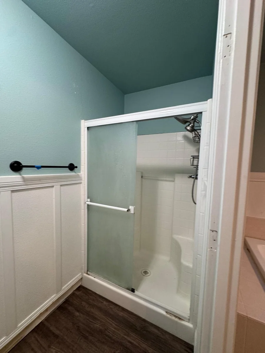 Original separate shower with light-colored framing in the South Hill bathroom