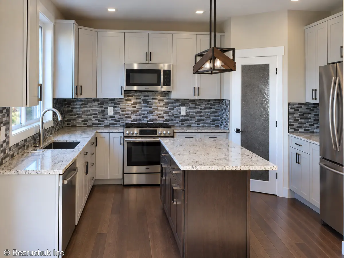 Completed Belmont kitchen in Puyallup with white cabinets, dark island and mosaic backsplash