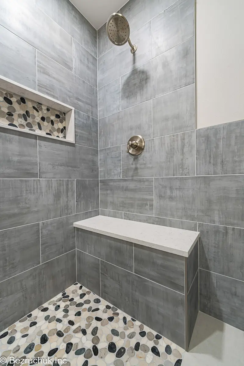 - project image Built-in shower bench beside a pebble floor and long recessed niche