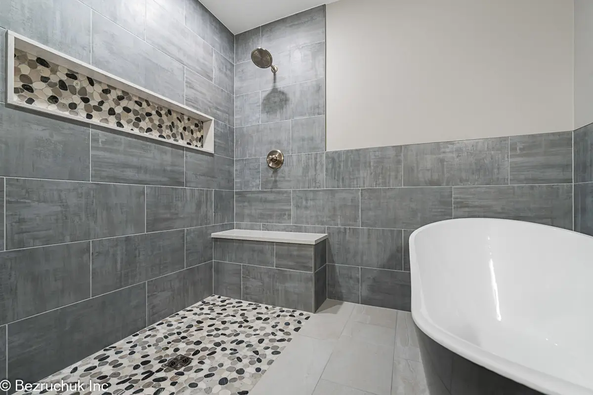 - project image Gray 12 by 24 wall tile around the shower and black-and-white freestanding tub