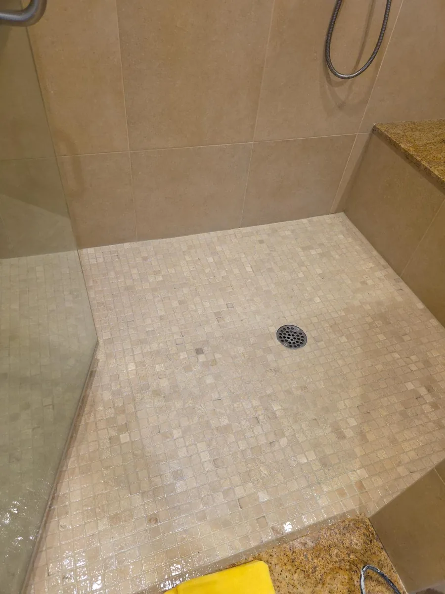 Completed Bellevue shower-floor regrouting with fresh grout between the existing square mosaic tiles