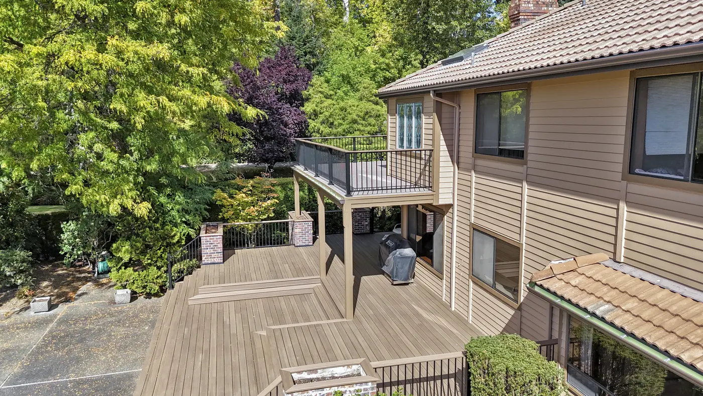 - project image The broad lower deck, upper balcony and steps at the Edgewood home.