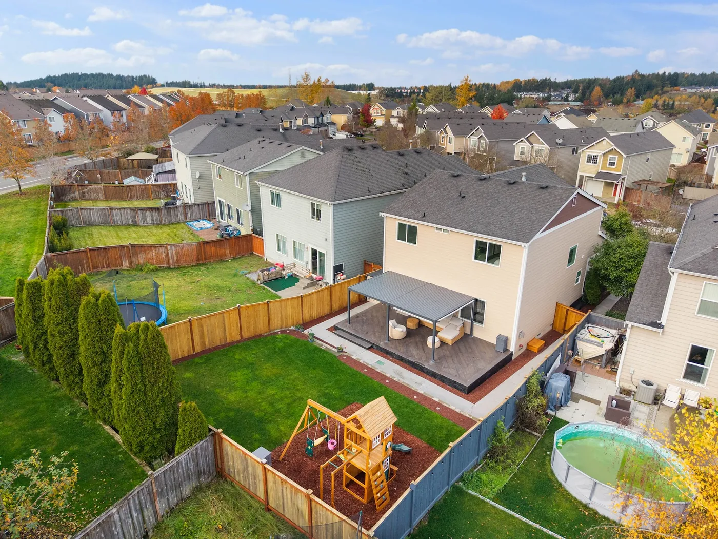- project image Aerial view of the Lipoma Firs home, tile deck, fenced backyard, lawn and play area.