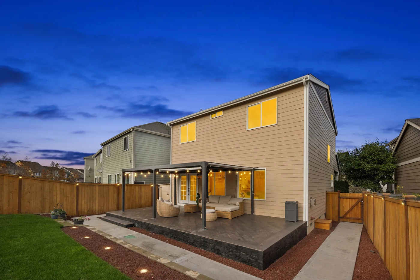 - project image Evening view of the tiled deck, pergola and fence lighting at the Lipoma Firs home.