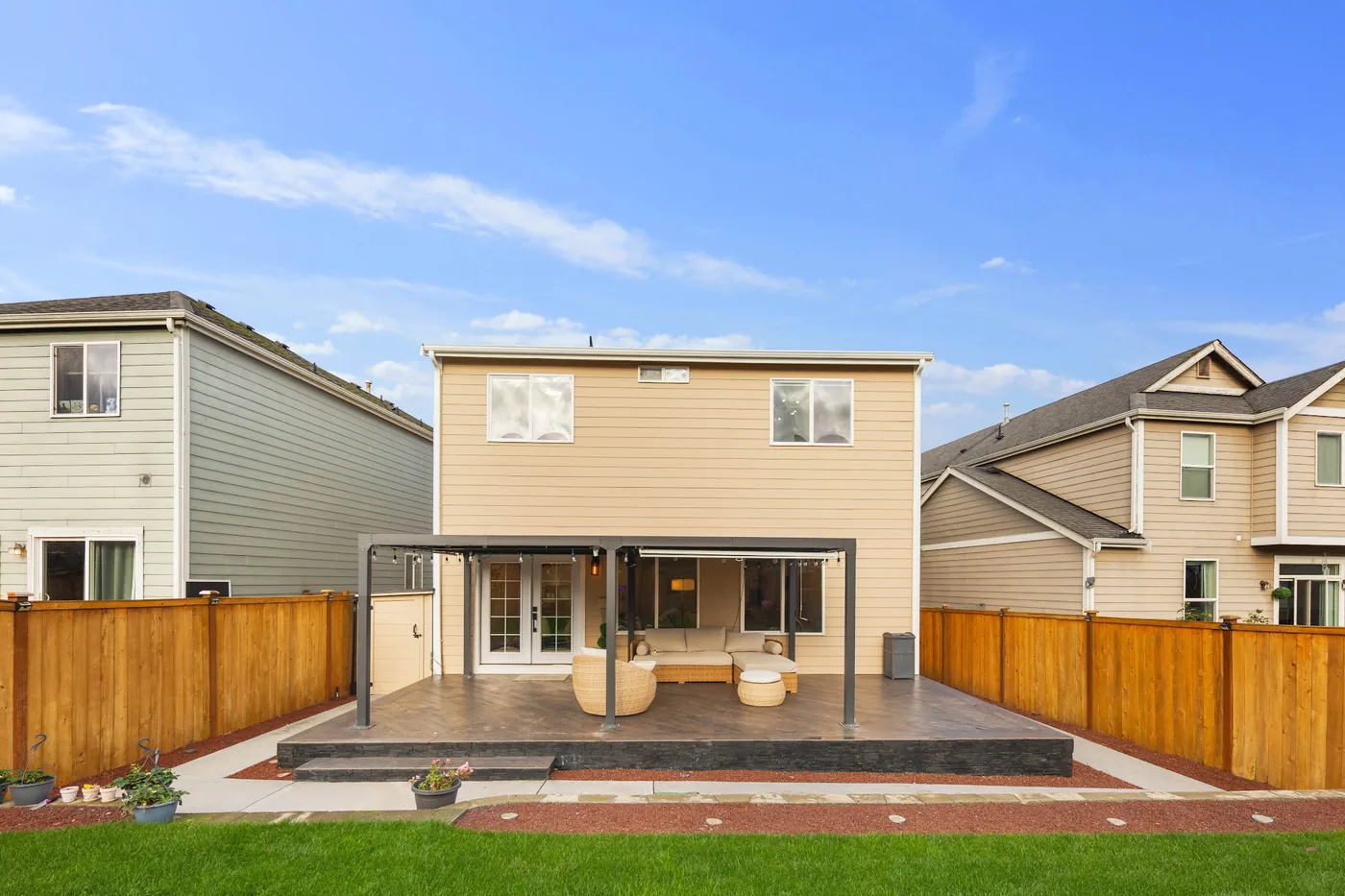 - project image Front view of the tiled concrete deck with wide steps and dark slate cladding beneath the pergola.