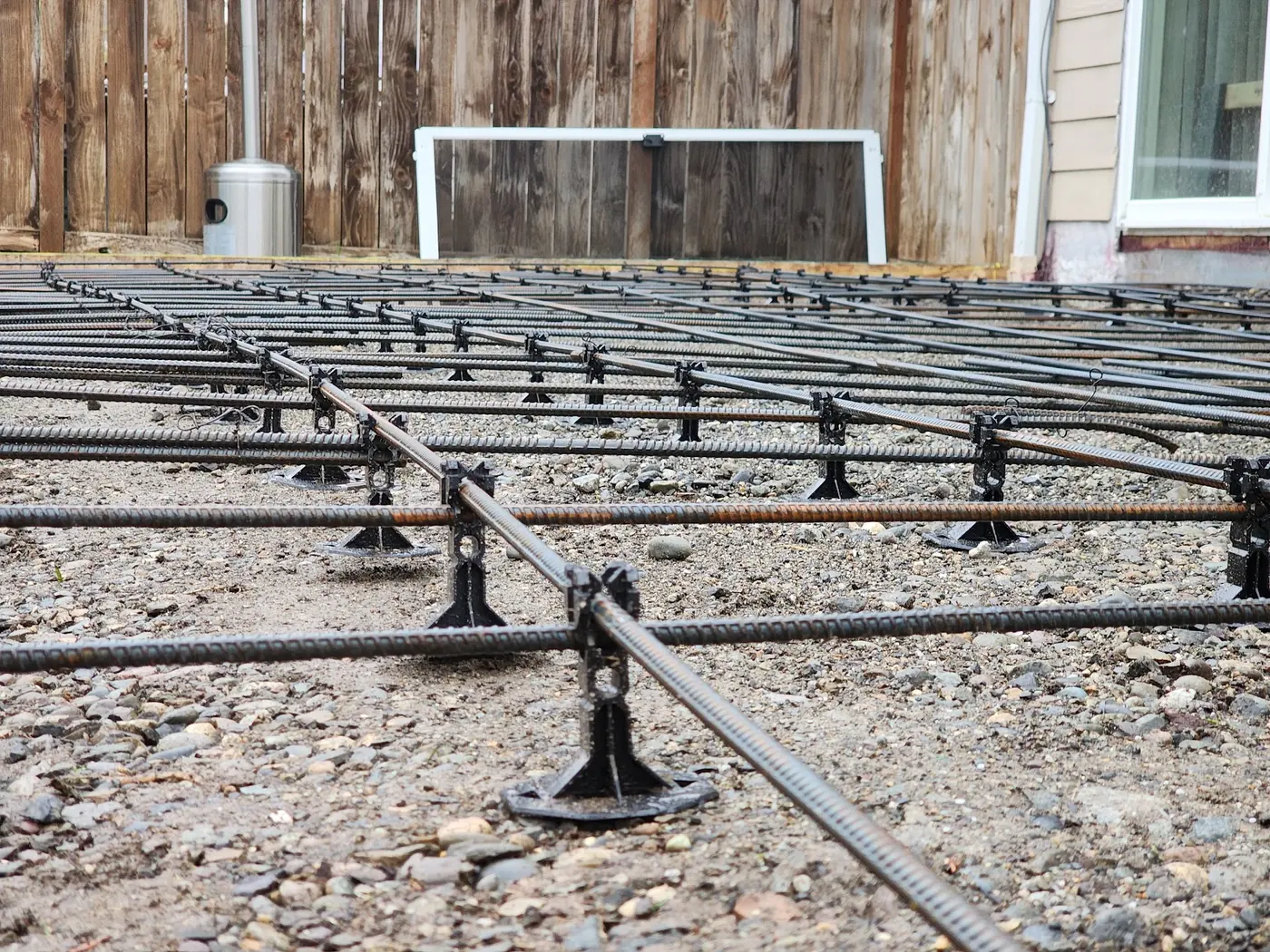 - project image Close view of reinforcing steel supported above the aggregate base before concrete placement.