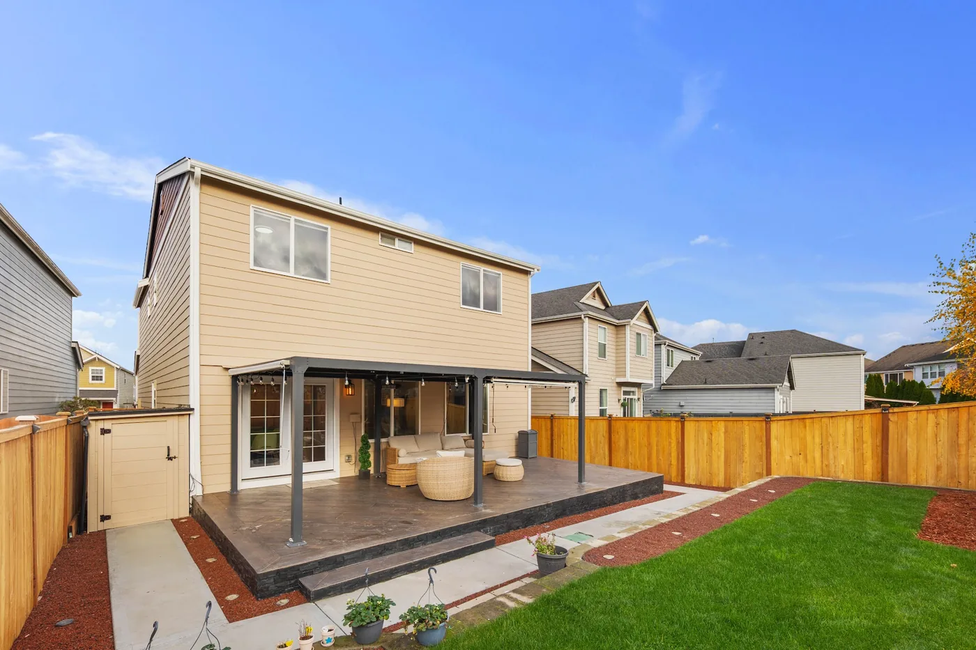 - project image Angled view of the completed porcelain tile deck, dark slate perimeter and wood privacy fence.